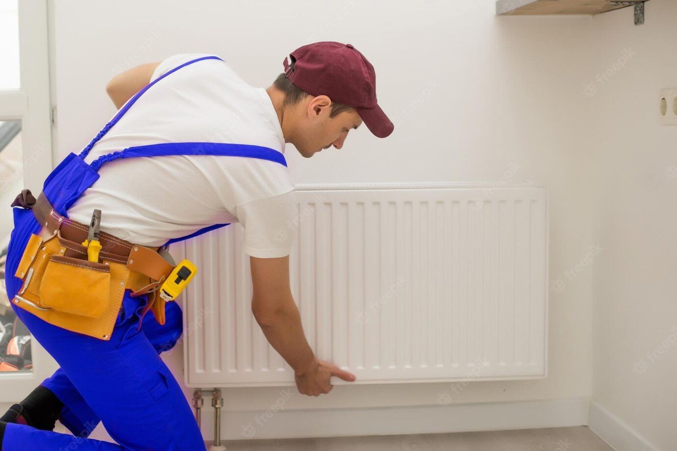 man work overalls using wrench while installing heating radiator room young plumber installing heating system apartment concept radiator installation plumbing works home renovation 493343 14466